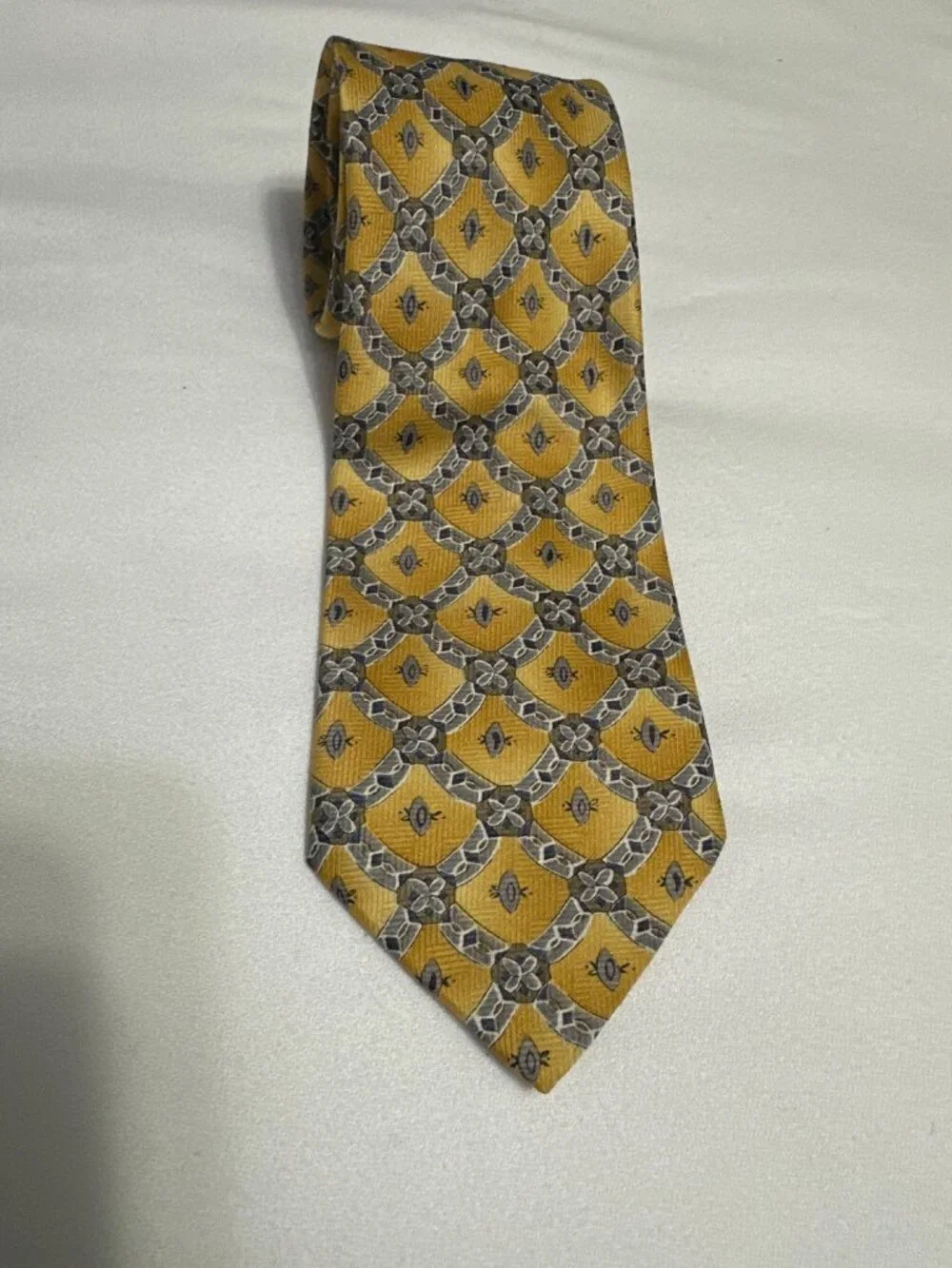 This is a vintage Ketch geometric medallion silk necktie, featuring a distinct g
